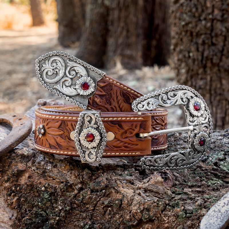 A silver three piece belt buckle set with red zirconias